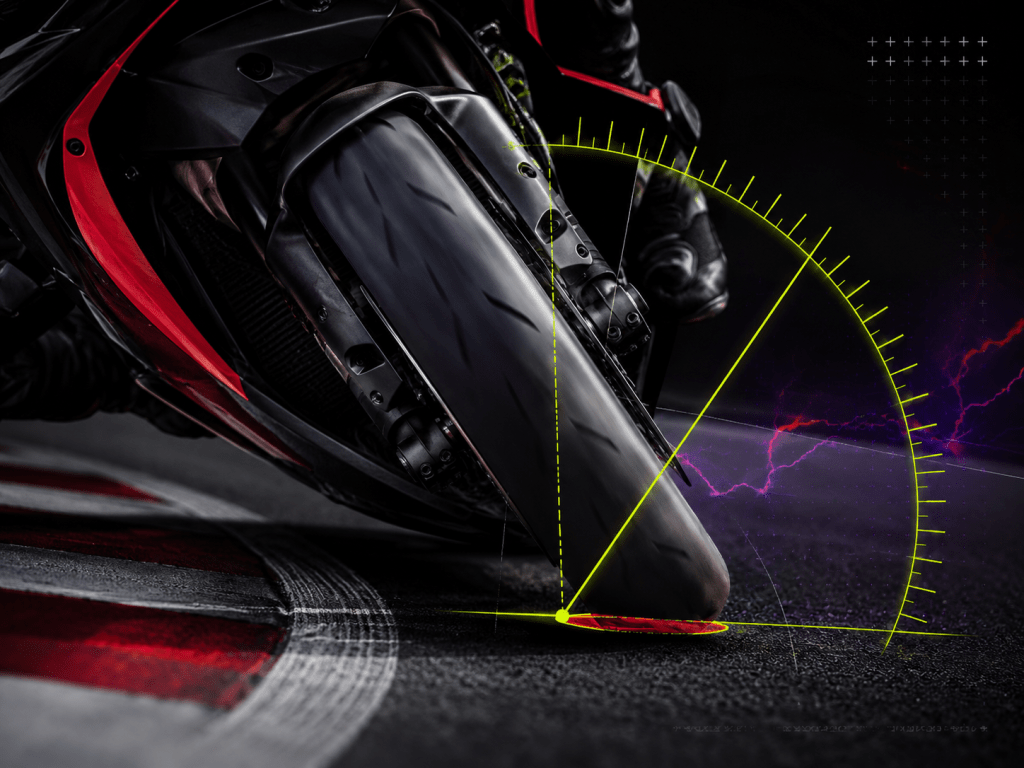 Close-up of a sportbike front tire leaned over with a degree arc showing motorcycle lean angle analysis.